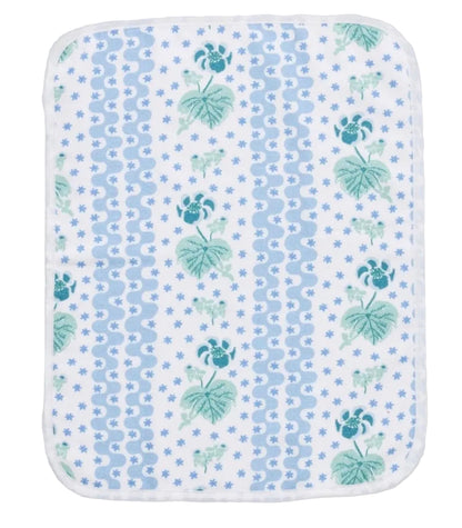 The Weezie x Lulie Wallace Beth Powder Bath Towel by Weezie Towels features a blue and green floral leaf pattern on white, rounded edges, and is crafted from absorbent terry cotton.