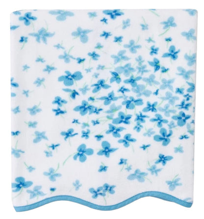 The Betty Floral Scallop Towel Collection by Weezie Towels features a square white quick-dry towel with a blue floral pattern and light blue wavy trim, combining elegance and function for your bath routine.