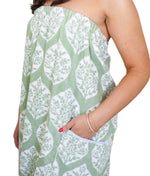 Person wears the Weezie Towels Ivy Block Towel Wrap, a green and white leafy design with an elastic back and pocket for a comfy, hands-free fit; only torso and one arm are shown.