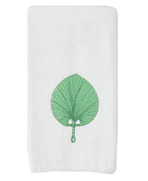 The Weezie x Meg Braff Fan Powder Bath Towel by Weezie Towels features a white design with an embroidered green leaf and a central handle, inspired by Meg Braff’s iconic Palm Beach style.