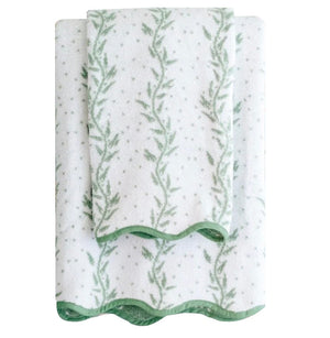 From the Willow Scallop Towel Collection by Weezie Towels, a smaller spa towel is folded atop a larger bath towel; both are white with green leafy vine patterns and scalloped edges.