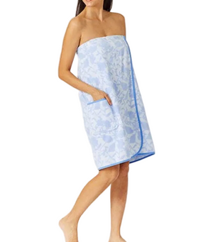 A woman models the Weezie Towels French Blue Floral Towel Wrap, featuring an elastic back and pocket, for a hands-free towel experience against a white background.
