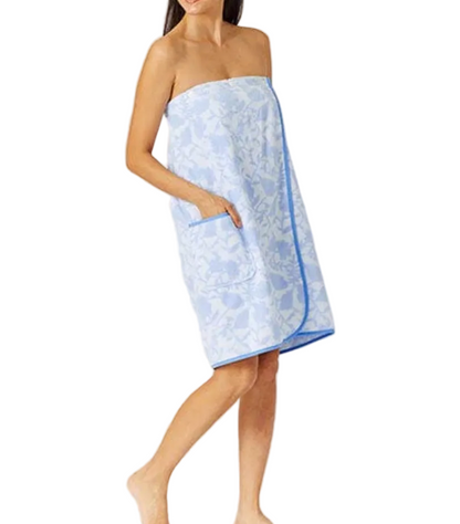 A woman models the Weezie Towels French Blue Floral Towel Wrap, featuring an elastic back and pocket, for a hands-free towel experience against a white background.