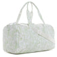 The TRVL Design Duffel Bag Weekender Collection features a white, water-resistant duffel with light green floral patterns, two handles, and an adjustable shoulder strap.