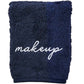 The Weezie Towels Makeup Towel is a navy terry towel embroidered with "makeup" in white script, offering a stylish and stain-resistant solution for your beauty routine.