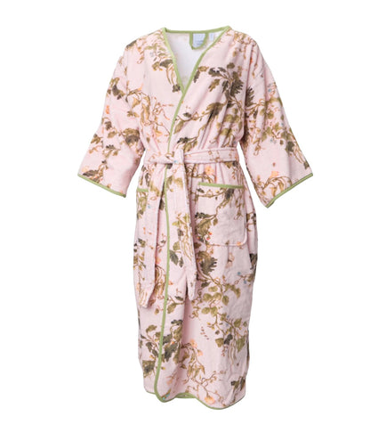 The Vivian Cherry Blossom Robe by Weezie Towels is a pink, floral-patterned velour robe with a belt and two front pockets, shown against a white background.