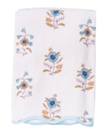 A folded white HIVE Home, Gift and Garden Floral Scallop Cora towel features blue and yellow floral patterns with a light blue scalloped trim along the edge.