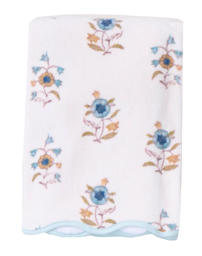 A folded white HIVE Home, Gift and Garden Floral Scallop Cora towel features blue and yellow floral patterns with a light blue scalloped trim along the edge.