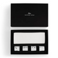 Michael Aram Reflective Napkin and Napkin Ring Gift Set featuring four metallic napkin rings with an irregular, textured finish and a white cotton napkin in a gift box.