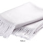 The Pezzo Throw Collection by Matouk features a folded, light silver cozy throw made of brushed cotton with fringed edges, displayed on a white background.
