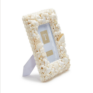The Coquillage Shell Frame, 5x7 by Two's Company stands upright on a white background, featuring assorted white seashells—perfect for adding coastal decor to any space.