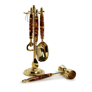 The Tortoise Bar Set by Two's Company includes a gold-toned spoon, bottle opener, and jigger on a stylish matching stand—ideal for enhancing any home bar.