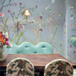 Dining table and patterned chairs in front of a scalloped mint green bench against a wall covered in de Gournay: Hand-Painted Interiors wallpaper.