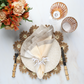 A table setting featuring the Kim Seybert Daisy Placemat, beige napkin with ring, two glasses, bamboo-handled cutlery, and orange flowers on a white surface—ideal for stylish outdoor gatherings.