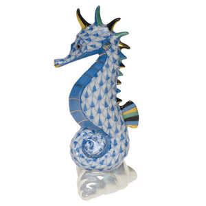 The Herend Sea Horse is a hand-painted porcelain figurine featuring a blue and white scale pattern, gold accents, and curled tail—an upright, charming collectible perfect for artistic appreciation.