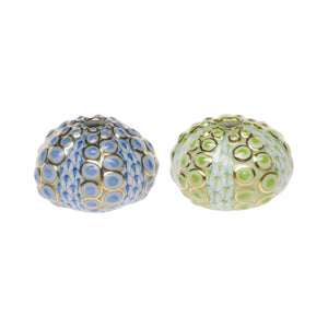 Two Herend Sea Urchin objects with raised circular patterns and hand-painted designs—one blue with gold accents, the other green with gold accents—are displayed on a white background, inviting artistic appreciation.