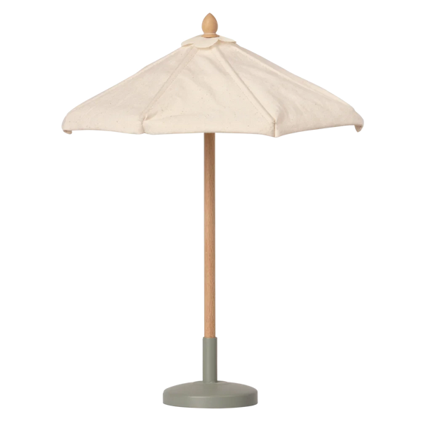 A Maileg Miniature Sunshade, featuring a beige canopy with a wooden pole and green base, is opened and standing upright on the terrace. Made from Cotton/FSC Wood/Metal, it's perfect for complementing the Mailegs Miniature garden set.