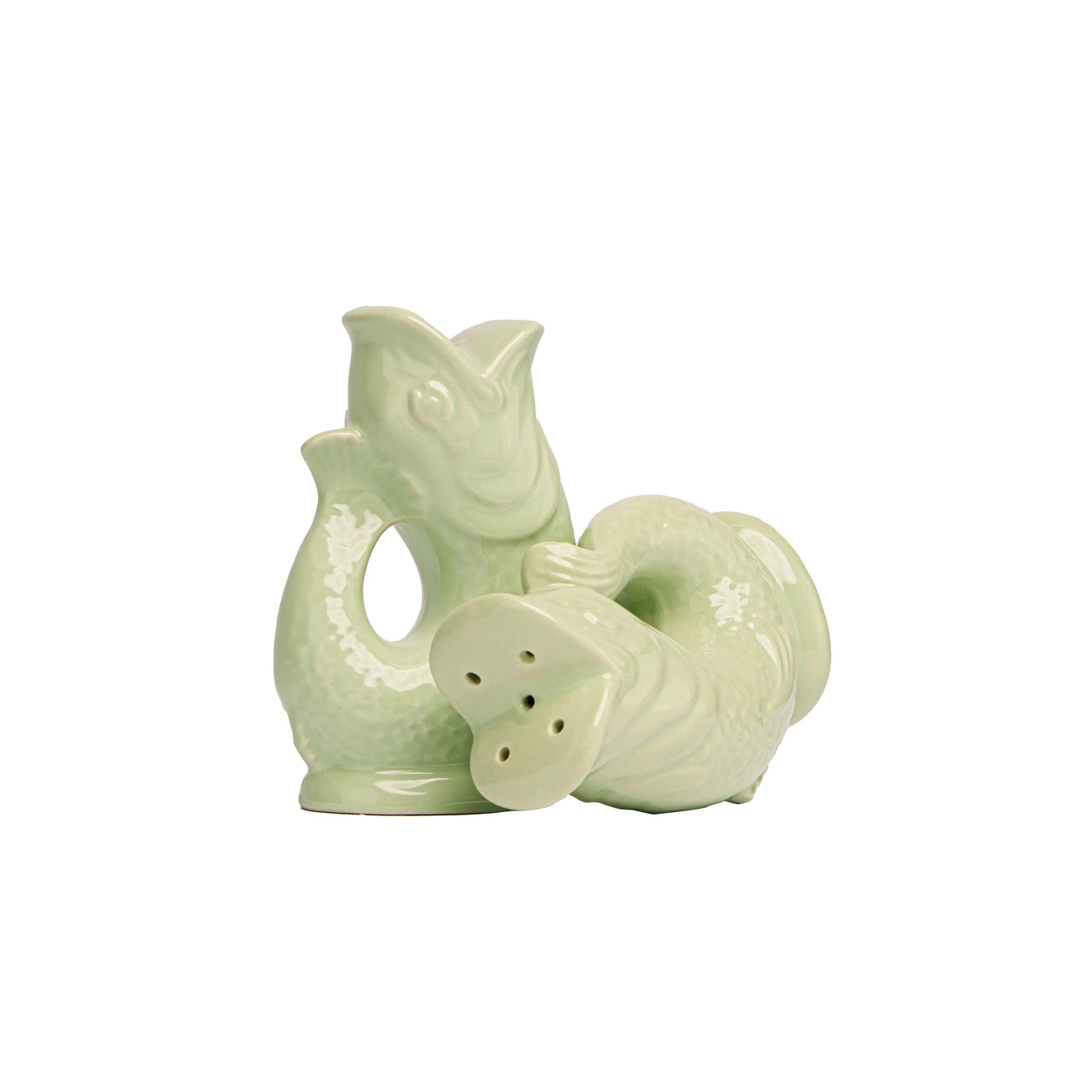 The Original Gluggle Jug Fish Salt & Pepper Shakers feature two light green ceramic fish—one upright, one on its side revealing shaker holes—inspired by the classic Gluggle Jug design.