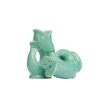 The Original Gluggle Jug's Fish Salt & Pepper Shakers feature two turquoise ceramic fish—one upright, one on its side—with bottom holes for shaking, inspired by the classic jug design.