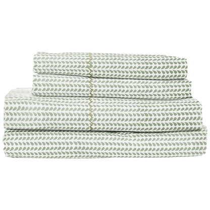 The John Robshaw Cinde Sage Bedding Collection features neatly folded green and white leaf-patterned cotton percale sheets and pillowcases in the charming Cinde print.