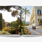 An open "Sicily Honor" coffee table book by Assouline displays lush gardens on the left page and two people walking near a palm-lined building on the right, evoking the charm of Sicilian travel.