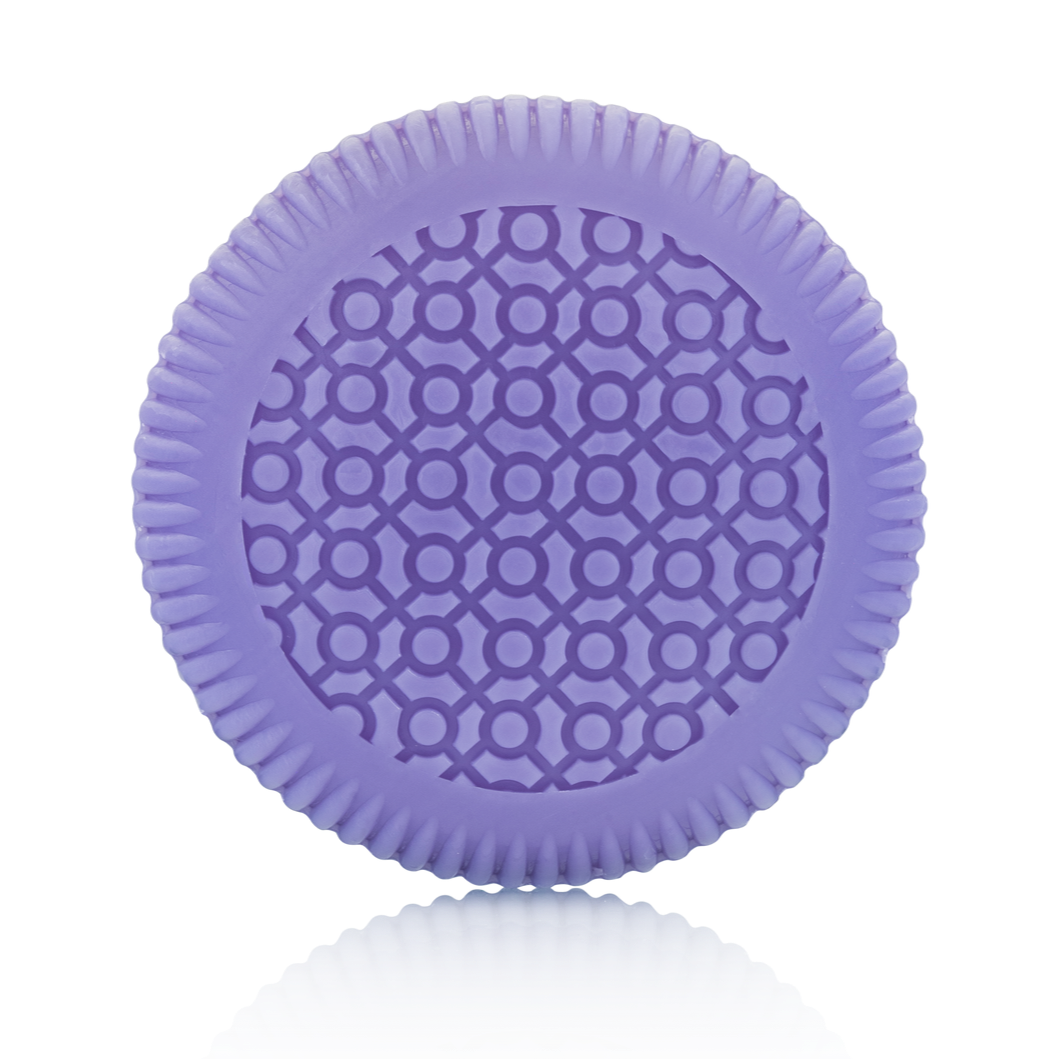 A round, purple object with a patterned surface of interlocking circles and lines from the Baobab Collection Gentlemen Body Wellness Collection by Baobab, displayed against a plain white background.