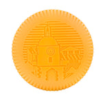 A round, orange biscuit with an embossed clock tower and buildings, inspired by Baobab’s Saint Tropez Body Wellness Collection and the lively summer essence of southern France.