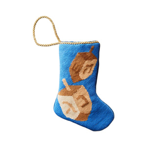 The Spin the Dreidel Needle Point Stocking by Bauble Stockings features two beige and brown dreidels on blue fabric with a gold loop—a charming Hanukkah ornament or unique holiday gift.