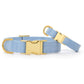 Two Blue Chambray Dog Collars by The Foggy Dog, featuring gold metal buckles and D-rings, are shown on a white background.