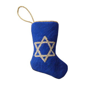 The Bauble Stockings Star of David Needle Point Stocking features a blue design with a gold Star of David and a shimmering gold loop, perfect for holiday gifting and displayed on a white background.