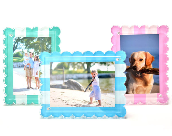 Three Tara Wilson Scallop Stripe Frames by Tara Wilson Designs display photos of a family, a child on the beach, and a dog with a stick, all arranged against a plain white background.