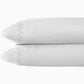 Two stacked white pillows with purple zigzag stitching on the edges, crafted from John Robshaw Stitched Sheet Set in Lavender organic cotton percale, set against a plain background.