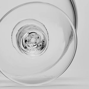 Close-up view of the circular base of a Simon Pearce Stratton Bowl, featuring a clear glass, textured, indented center.
