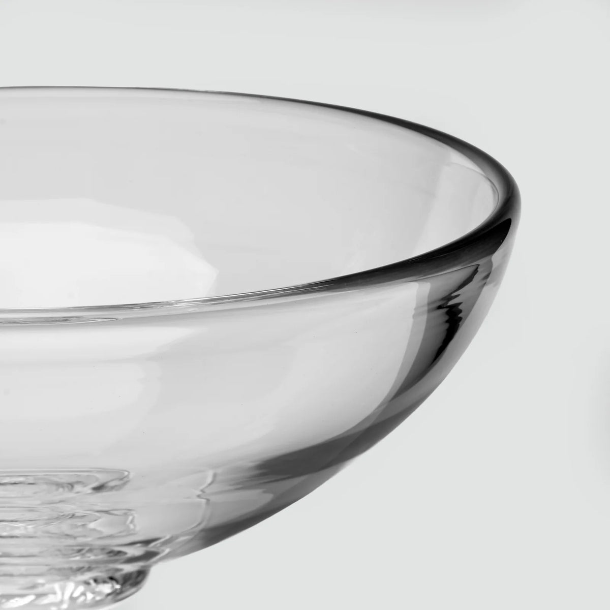 Close-up of a Simon Pearce Stratton Bowl made of clear glass with a thick, rounded rim.