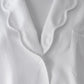 Close-up of the Sue Nightshirt by Haute Home in cotton sateen, with wavy collar, single white button, chest pocket, and ribbed white undershirt—a touch of refined comfort in elegant sleepwear.