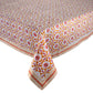 A rectangular table adorned with a Kim Seybert Majorelle Tablecloth Collection piece, showcasing orange and pink florals, a striped border, and intricate handmade Indian block print details.