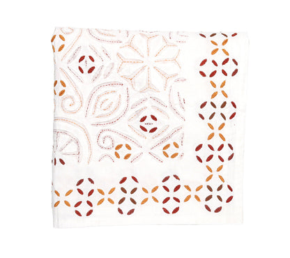 A white cloth napkin from the Malta Tablecloth Collection by Kim Seybert, featuring geometric and floral embroidery in red, orange, and brown—an elegant accent to complement your Malta Tablecloth.