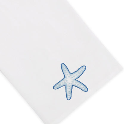Elevate your home décor with the Playful Starfish Bath Collection from Haute Home: a white premium linen fabric napkin featuring a blue starfish embroidered in one corner, combining elegance with coastal charm.