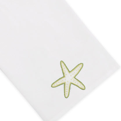 The Haute Home Playful Starfish Bath Collection features a white cloth napkin made from premium linen, beautifully accented with a green and yellow embroidered starfish motif in one corner—an elegant touch for your home décor.