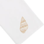 Haute Home’s Speckled Conch Coaster & Bath Collection features a white Italian linen napkin adorned with an embroidered beige seashell motif on one corner, shown against a crisp white background—an ideal accent to infuse coastal elegance into your linen home decor.