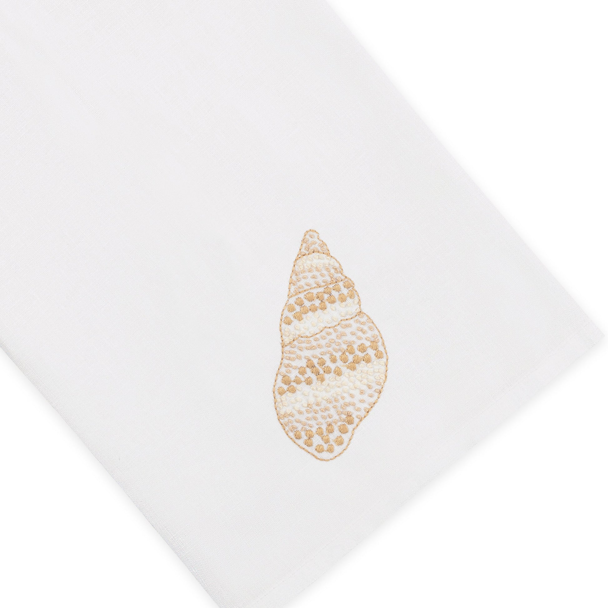 Haute Home’s Speckled Conch Coaster & Bath Collection features a white Italian linen napkin adorned with an embroidered beige seashell motif on one corner, shown against a crisp white background—an ideal accent to infuse coastal elegance into your linen home decor.