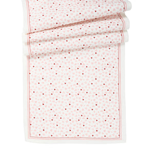 The Juliska "Love You More" Table Runner features a rectangular white design with red and pink small heart patterns and a thin red border—perfect for festive table decor.