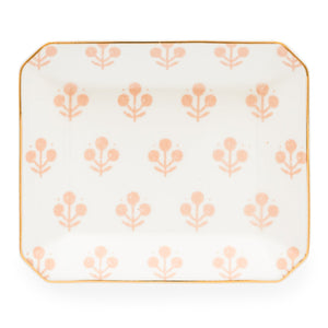 The Rose Floral Trinket Tray by Sugar Paper is a rectangular white ceramic tray with rounded corners, featuring a repeating light pink floral pattern and elegant gold detailing along the edge.