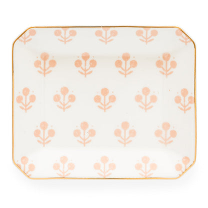 The Rose Floral Trinket Tray by Sugar Paper is a rectangular white ceramic tray with rounded corners, featuring a repeating light pink floral pattern and elegant gold detailing along the edge.