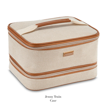 A beige textured train case with brown trim, zipper closure, and top handle from Stephanie Johnson's Tropea Travel Collection. Features removable compartments for organized storage and easy access to essentials.