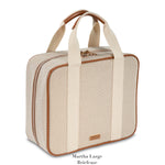 The Tropea Travel Collection by Stephanie Johnson is a beige and tan fabric briefcase with brown trim, two short handles, a zip closure, and removable compartments for versatile use.