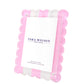 The Scallop Stripe Frame by Tara Wilson Designs features scalloped pink edges, clear lucite, and a white card insert—an elegant addition inspired by our best-selling frame collection.