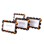 The Scallop Place Card Holder Set by Tara Wilson Designs includes four acrylic tortoiseshell-patterned rectangle holders with scalloped edges, each displaying a “PLACECARD HOLDER” card.
