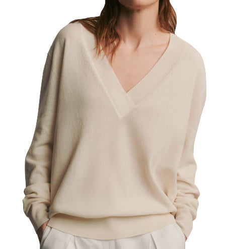 Woman wearing a TWP Deep V Cashmere Sweater, cream-colored v-neck sweater.