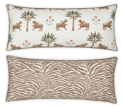 The Matouk Reversible Lumbar Pillow Collection offers versatile home decor with one side featuring tigers, palm trees, and flowers on white, and the other a tan and white zebra stripe pattern.